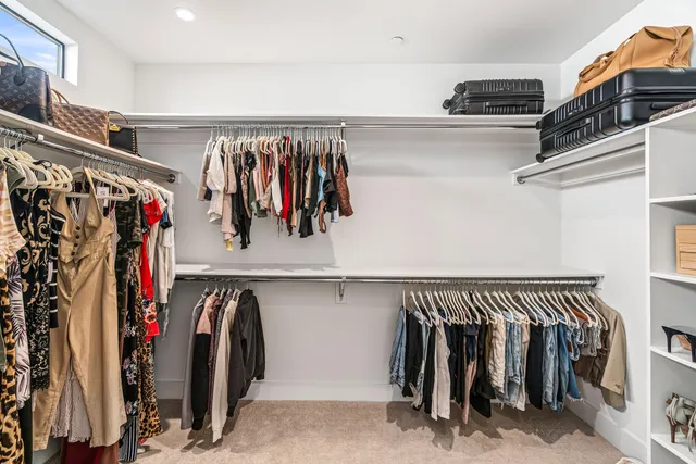 a view of walk in closet with clothes and shoes