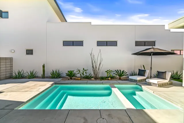 a patio with a table and chairs under an umbrella