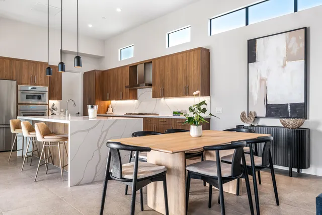 a kitchen with a table chairs refrigerator and cabinets