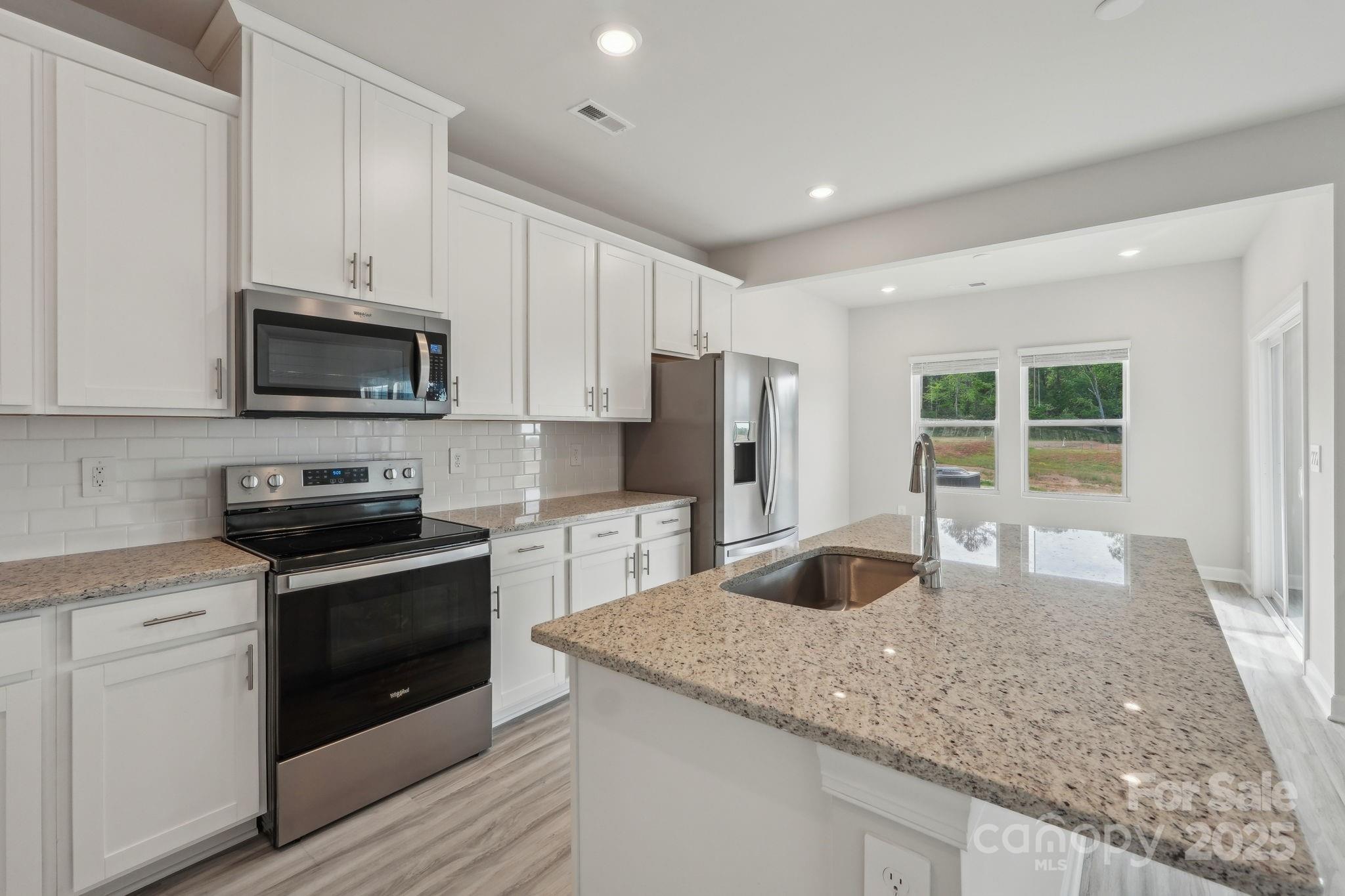 1321 30th St Lane Northeast Conover, NC 28613 - Photo 11 of 27 a kitchen with granite countertop a sink stove and refrigerator
