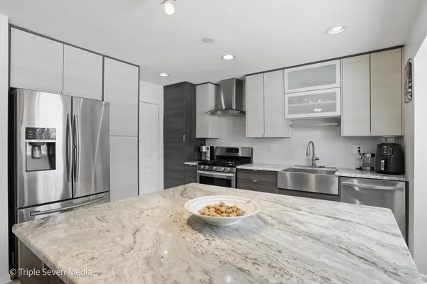 a kitchen with stainless steel appliances granite countertop a sink refrigerator and microwave