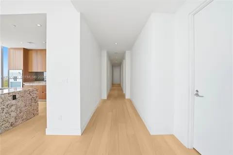 a view of empty room with wooden floor and floor to ceiling window