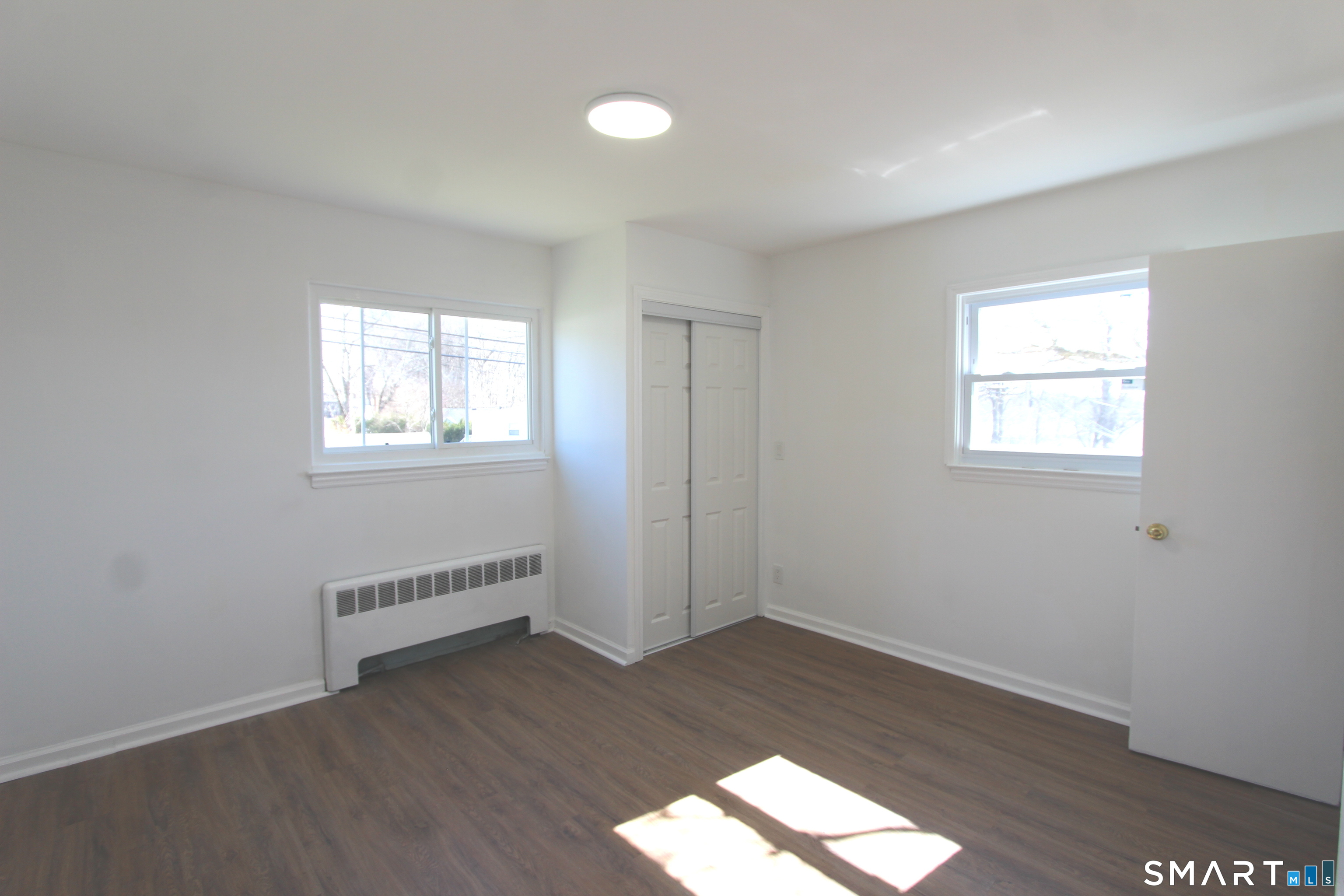 52 Glen Haven Road New Haven, CT 06513 - Photo 7 of 15 an empty room with wooden floor and windows