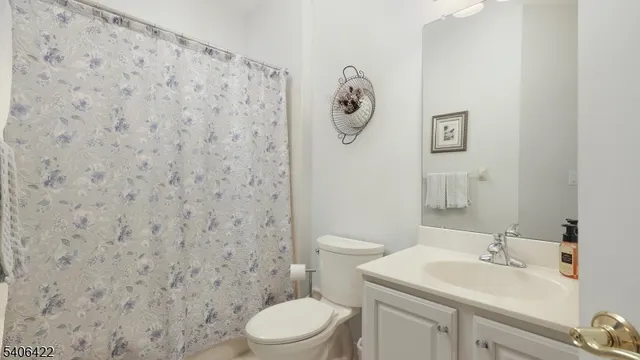 a bathroom with a toilet a sink and a shower curtain