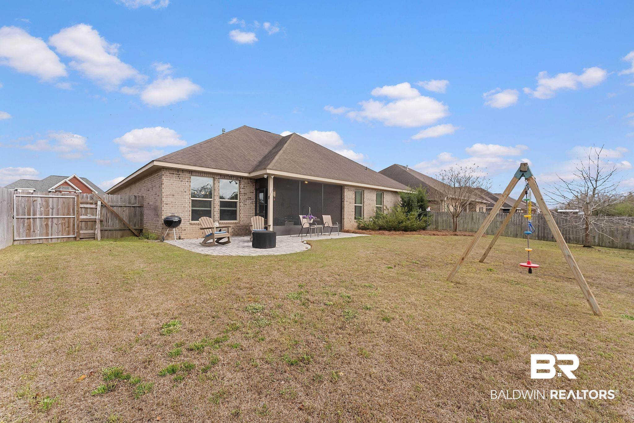 7015 Rocky Rd Loop Gulf Shores, AL 36542 - Photo 39 of 41 Rear view of house featuring brick siding, a patio, a sunroom, and a fenced backyard