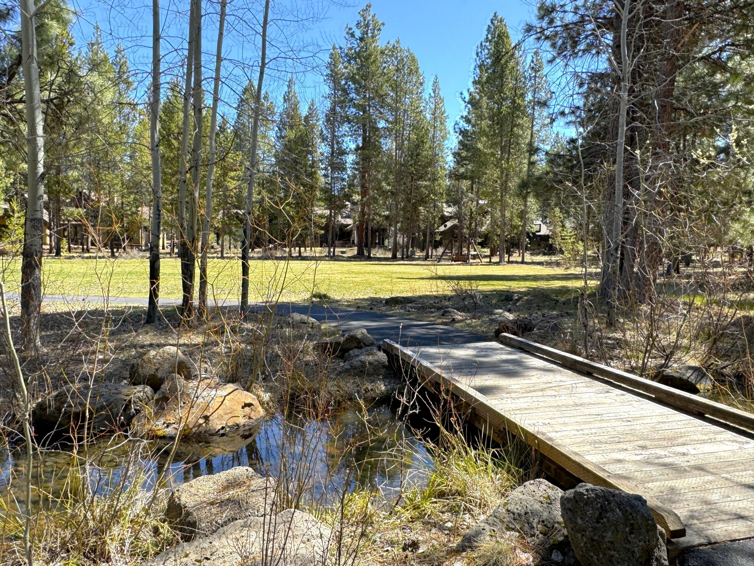 56290 Sable Rock Loop, Unit 257 Bend, OR 97707 - Photo 3 of 22 Lot 257 offers a rare opportunity to own property adjacent to the serene and beautifully maintained Sable Rock Park. This expansive green space, lined with towering Ponderosa pines, creates a picturesque setting ideal for family recreation?from casual soccer matches to impromptu games of baseball or frisbee. A charming walking path meanders through the park alongside a seasonal creek, connecting to two lush ponds at either end. It?s a perfect spot for morning bike rides, peaceful strolls, or unforgettable hide-and-seek adventures. Whether you're looking to build your dream home or invest in a highly desirable location, Lot 257 provides the natural beauty, tranquility, and recreation that make everyday living feel like a getaway.