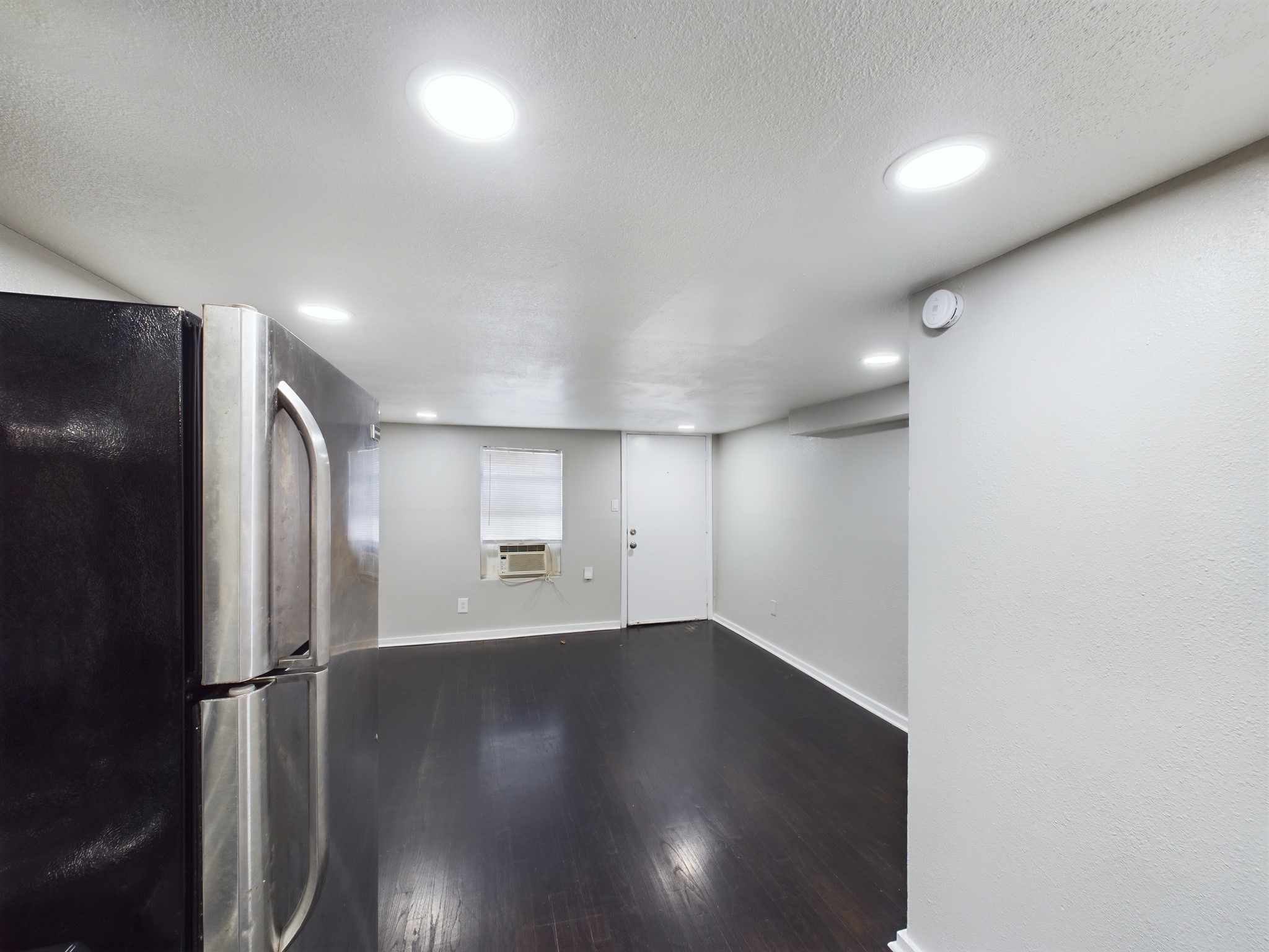 605 Enid 1/2 2 Street Houston, TX 77009 - Photo 3 of 7 an empty room with wooden floor and windows