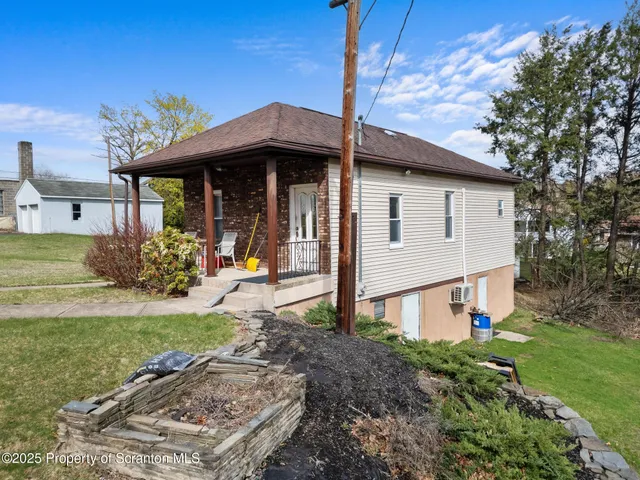 a view of a house with a wooden deck and a yard