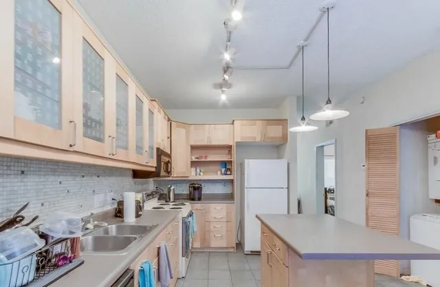a kitchen with a sink a refrigerator and cabinets