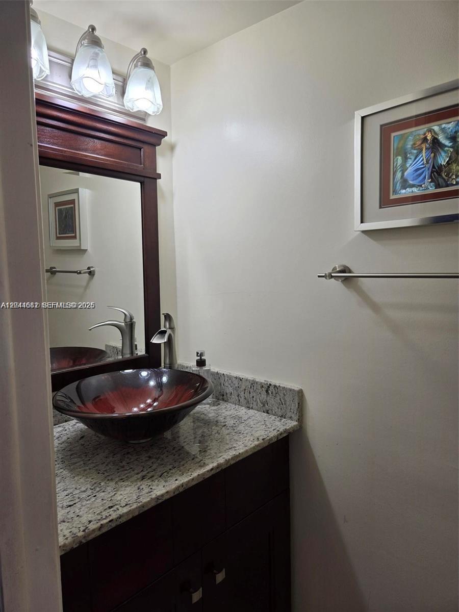 2174 West 60th Street, Unit 17205 Hialeah, FL 33016 - Photo 6 of 11 a bathroom with a granite countertop sink and a mirror
