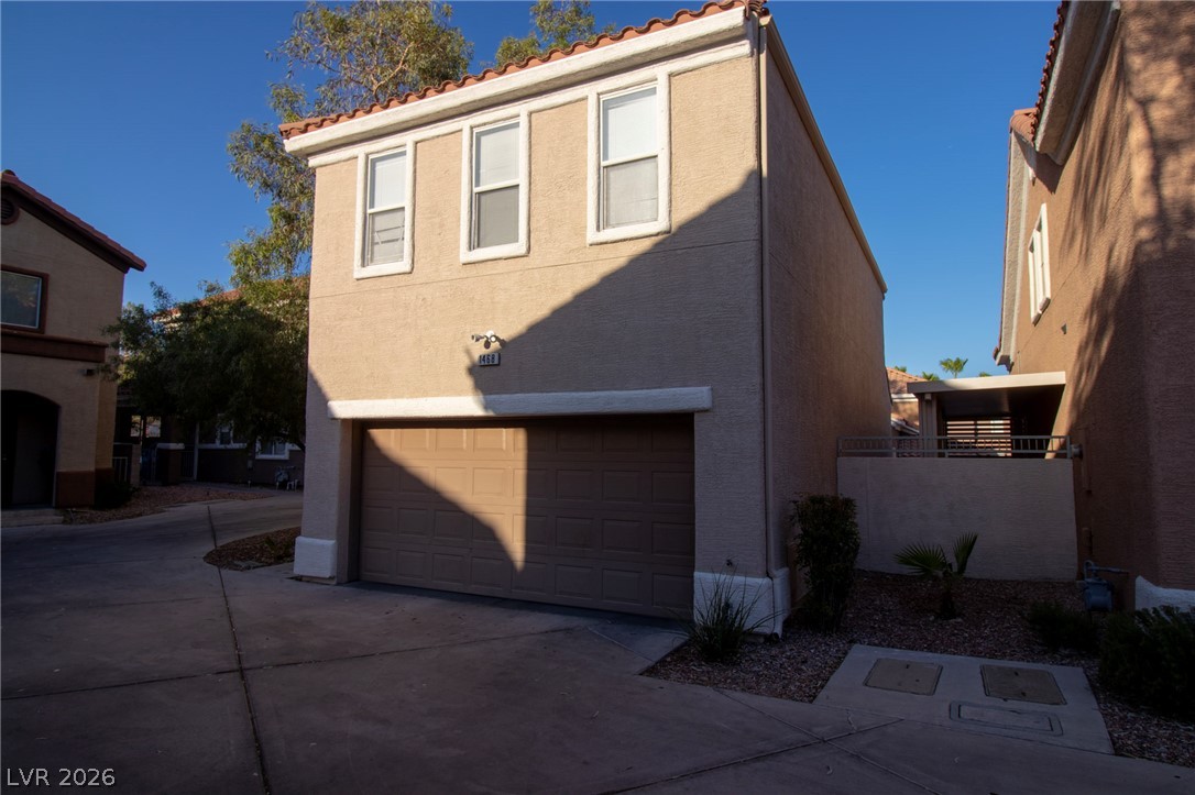 1468 Reef Ridge Court Las Vegas, NV 89128 - Photo 2 of 22 A two-story stucco exterior offers private garage parking and a charming tile roof.