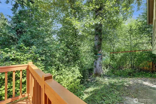 a balcony with wooden floor and yard in the back
