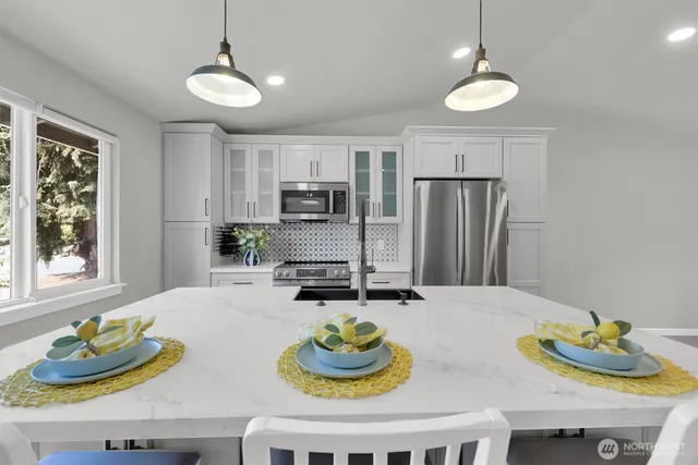 a kitchen with granite countertop a table and chairs