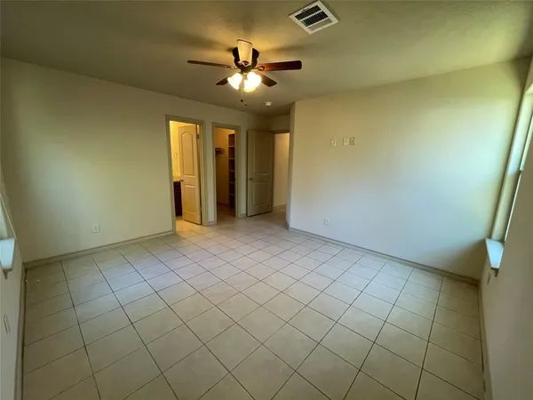 a view of an empty room with a chandelier fan