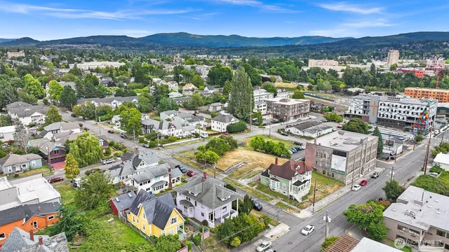 an aerial view of a city with lots of residential buildings and mountain view in back
