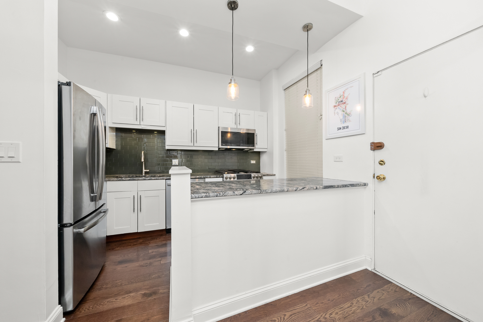 3055 North Seminary Avenue, Unit 3S Chicago, IL 60657 - Photo 6 of 23 a kitchen with kitchen island a sink stainless steel appliances and cabinets