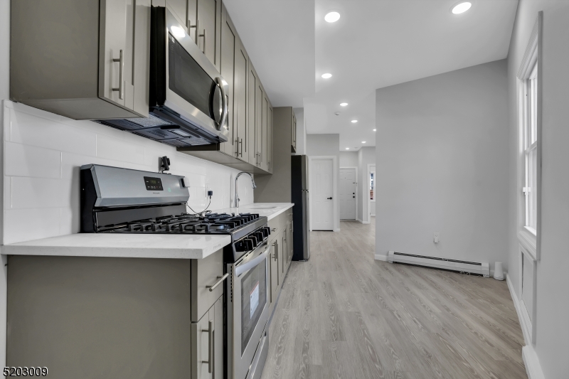 167 Smith Street, Unit 1L Elizabeth, NJ 07201 - Photo 4 of 8 a kitchen with stainless steel appliances granite countertop a stove and a refrigerator