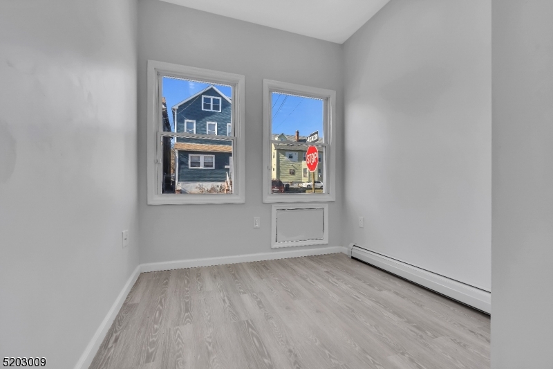 167 Smith Street, Unit 1L Elizabeth, NJ 07201 - Photo 7 of 8 an empty room with painting on the wall and a window