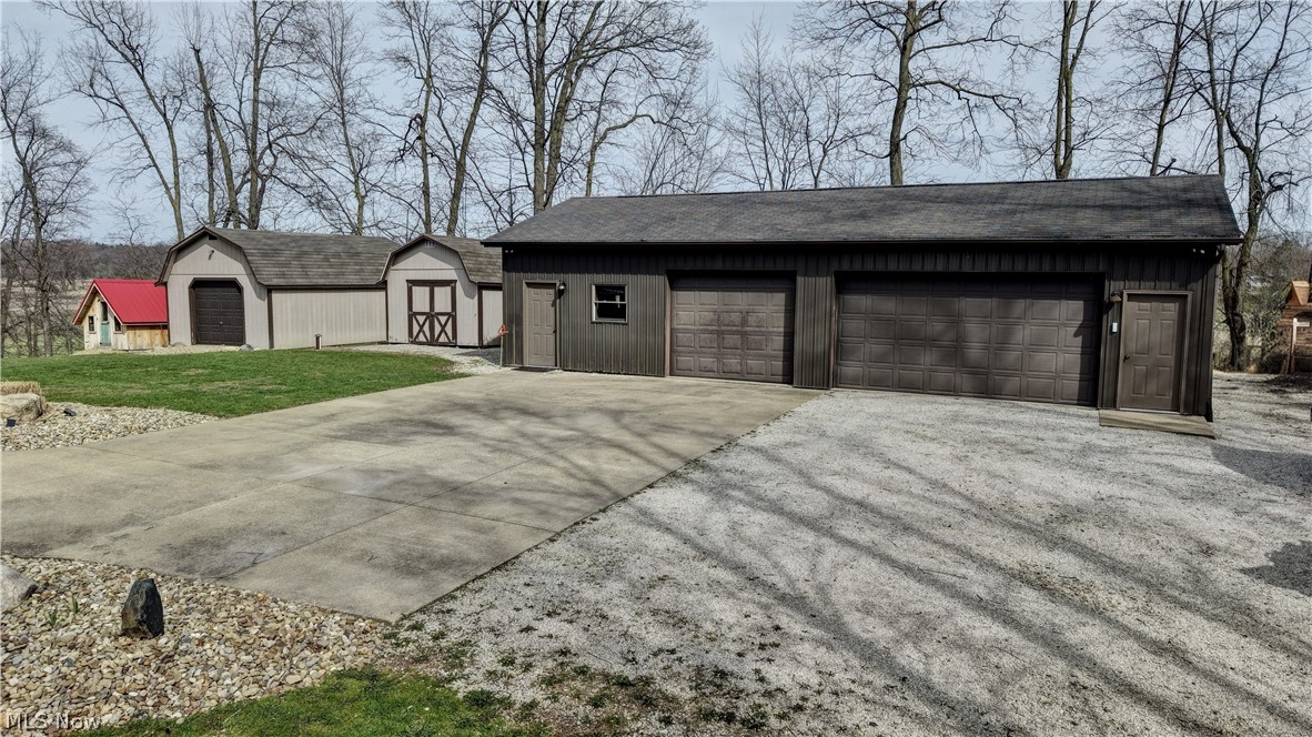 8045 McFadden Road Shreve, OH 44676 - Photo 16 of 45 View of front of property with a detached garage, a shingled roof, and a storage shed