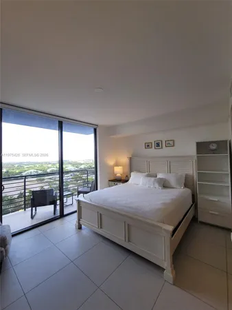 a bedroom with a balcony a bed and a night stand