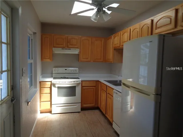a kitchen with stainless steel appliances granite countertop a refrigerator and a stove top oven