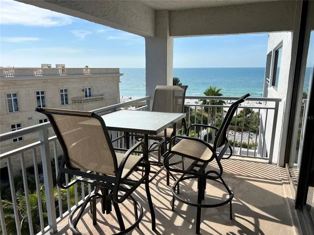 a view of a chairs and table in the balcony