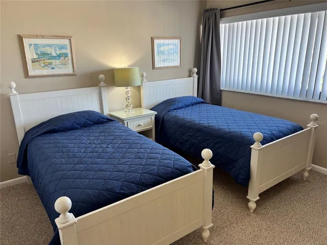 a bed sitting in a bedroom next to a lamp