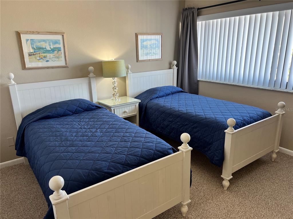 1001 Point Of Rocks Road, Unit 608 Sarasota, FL 34242 - Photo 12 of 33 a bed sitting in a bedroom next to a lamp