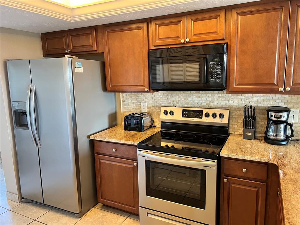 1001 Point Of Rocks Road, Unit 608 Sarasota, FL 34242 - Photo 5 of 33 a kitchen with stainless steel appliances granite countertop a stove microwave and refrigerator