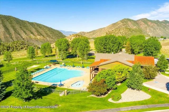 a view of a swimming pool with an outdoor seating and a mountain view