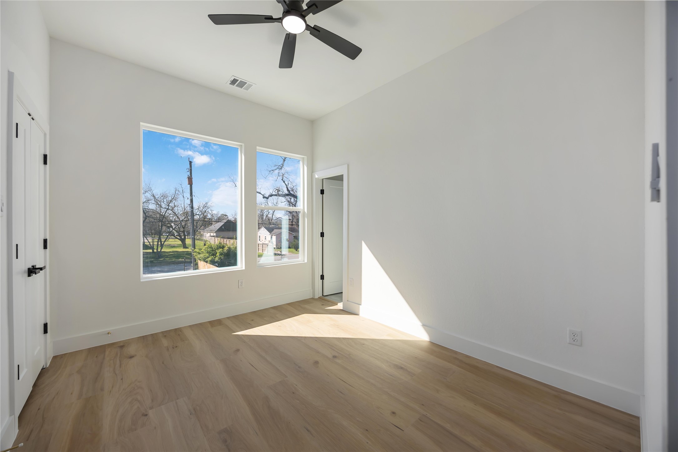 4533 Bricker Street Houston, TX 77051 - Photo 17 of 21 an empty room with wooden floor fan and windows