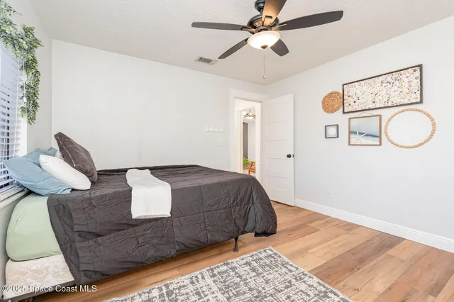 a bedroom with a bed and wooden floor