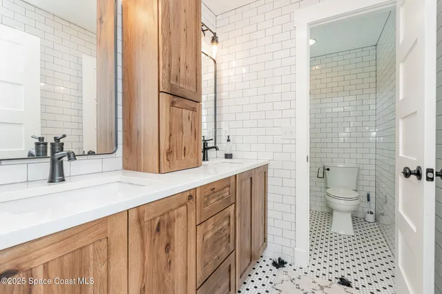 a bathroom with a sink a toilet and a mirror