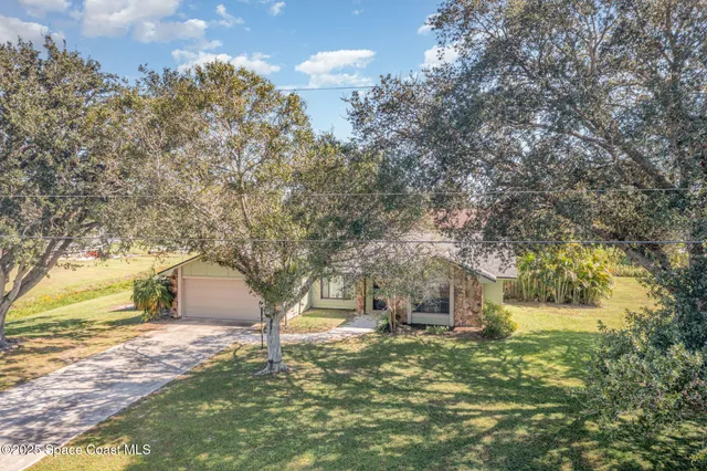 a yellow house in middle of a field