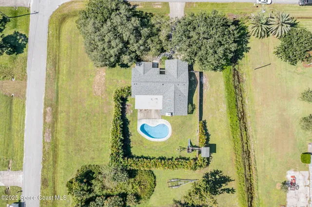 an aerial view of a residential houses with yard