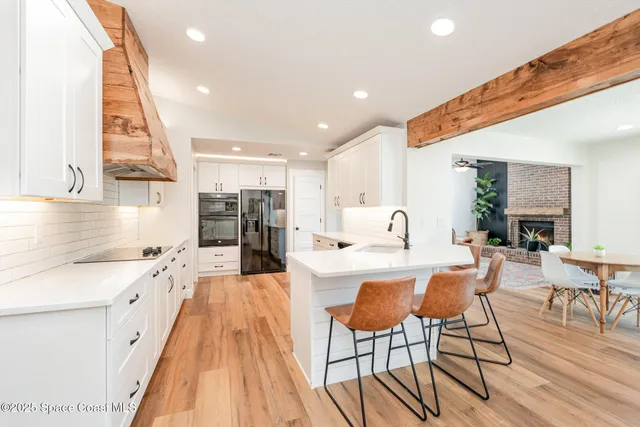 a large kitchen with stainless steel appliances kitchen island granite countertop a large counter top and a stove top oven