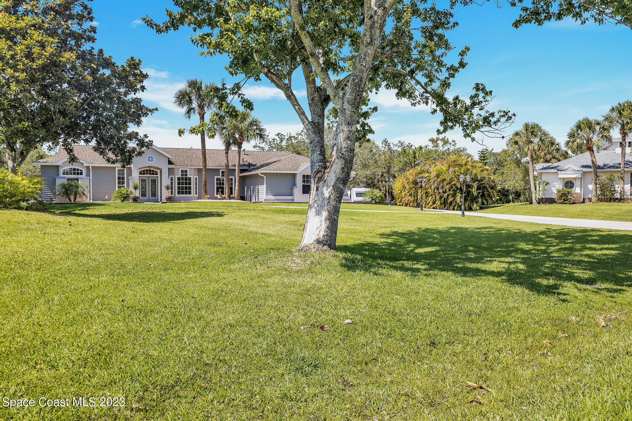 4320 Canard Road Melbourne, FL 32934 - Photo 54 of 78 a view of a big house with a big yard and large trees