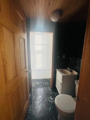 a white toilet sitting next to a bathroom sink and a window