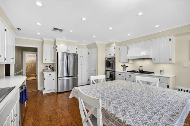 a large kitchen with stainless steel appliances kitchen island granite countertop a refrigerator and a stove top oven