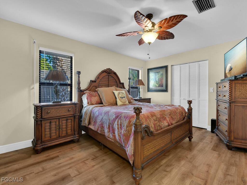 9041 Hamlin Road West Fort Myers, FL 33967 - Photo 15 of 34 a bedroom with a large bed and a ceiling fan