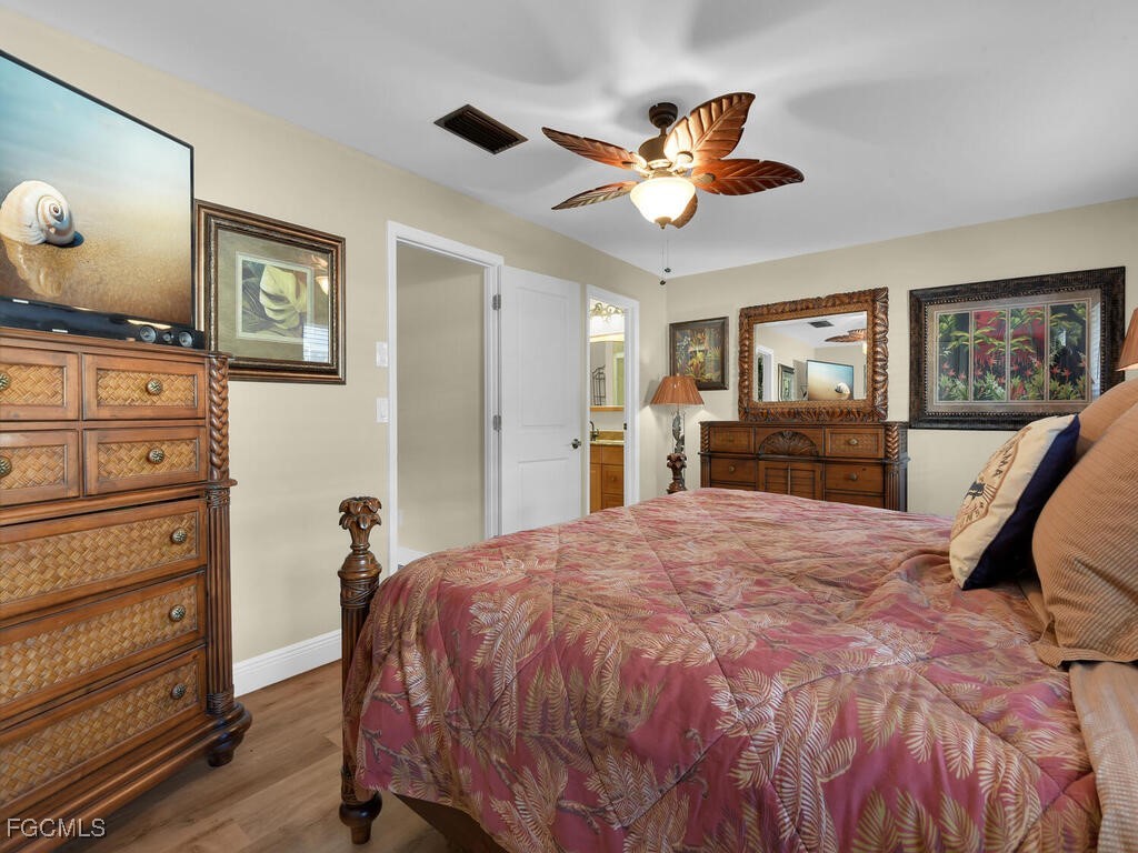 9041 Hamlin Road West Fort Myers, FL 33967 - Photo 16 of 34 a bedroom with a bed and a chandelier