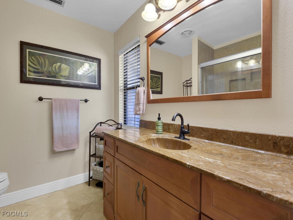 9041 Hamlin Road West Fort Myers, FL 33967 - Photo 17 of 34 a bathroom with a granite countertop sink and a mirror