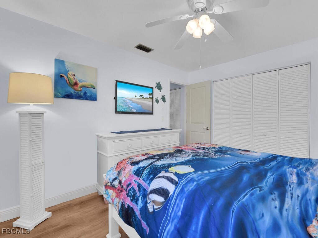 9041 Hamlin Road West Fort Myers, FL 33967 - Photo 20 of 34 a bedroom with a bed and a chandelier