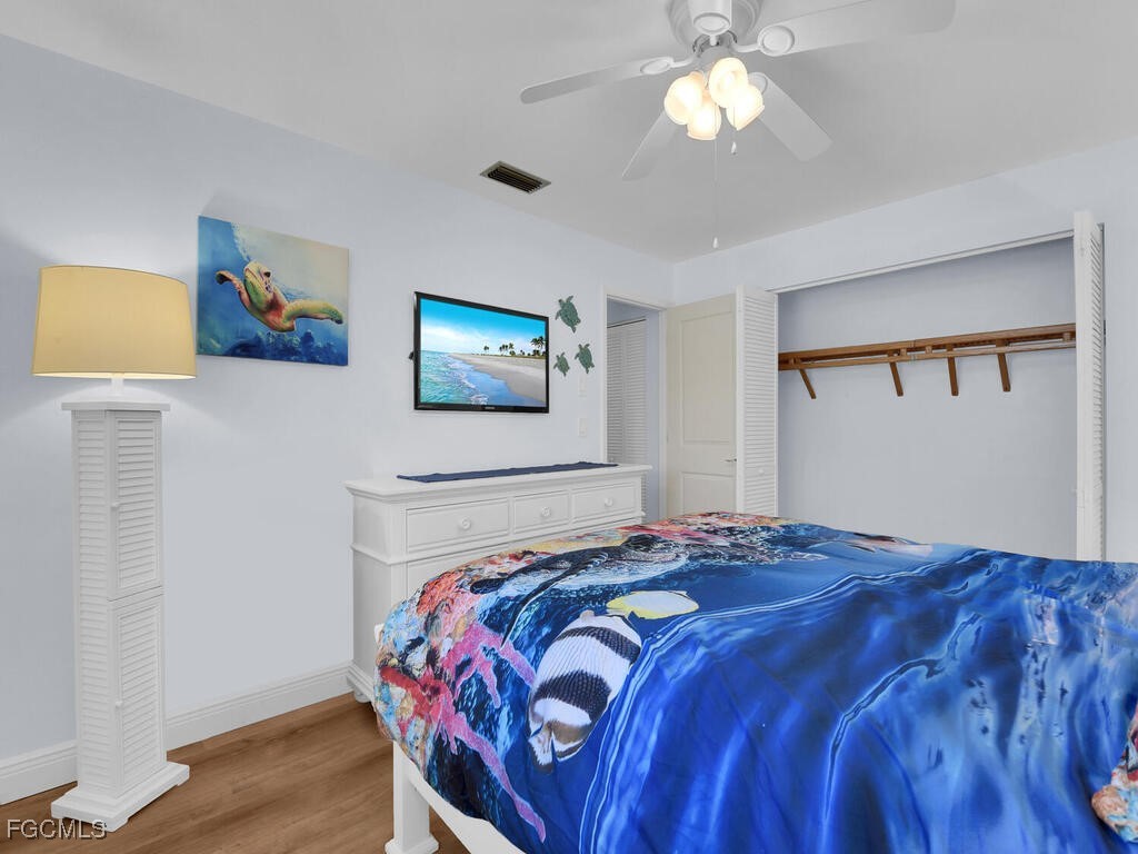 9041 Hamlin Road West Fort Myers, FL 33967 - Photo 21 of 34 a bedroom with a bed and a chandelier