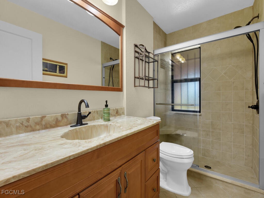 9041 Hamlin Road West Fort Myers, FL 33967 - Photo 22 of 34 a bathroom with a granite countertop sink toilet and shower