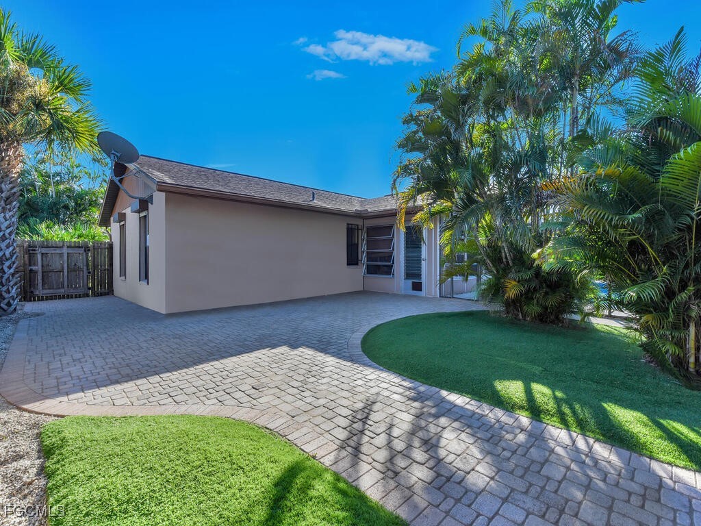 9041 Hamlin Road West Fort Myers, FL 33967 - Photo 29 of 34 a front view of a house with a garden
