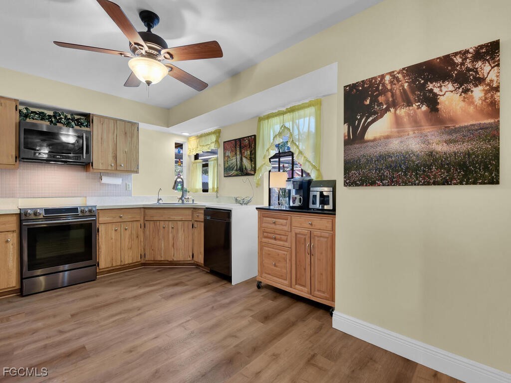 9041 Hamlin Road West Fort Myers, FL 33967 - Photo 7 of 34 a kitchen with stainless steel appliances granite countertop a stove a sink and a microwave