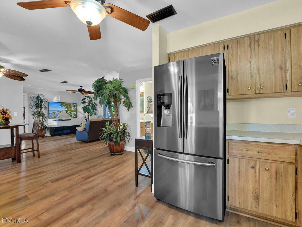 9041 Hamlin Road West Fort Myers, FL 33967 - Photo 9 of 34 a kitchen with stainless steel appliances a refrigerator a stove a sink cabinets and wooden floor