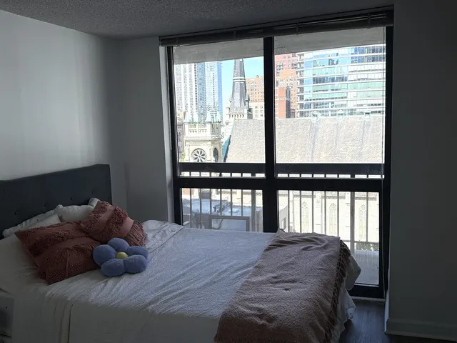 a bedroom with a bed and a large window