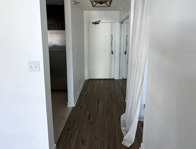 a view of a hallway with wooden floor